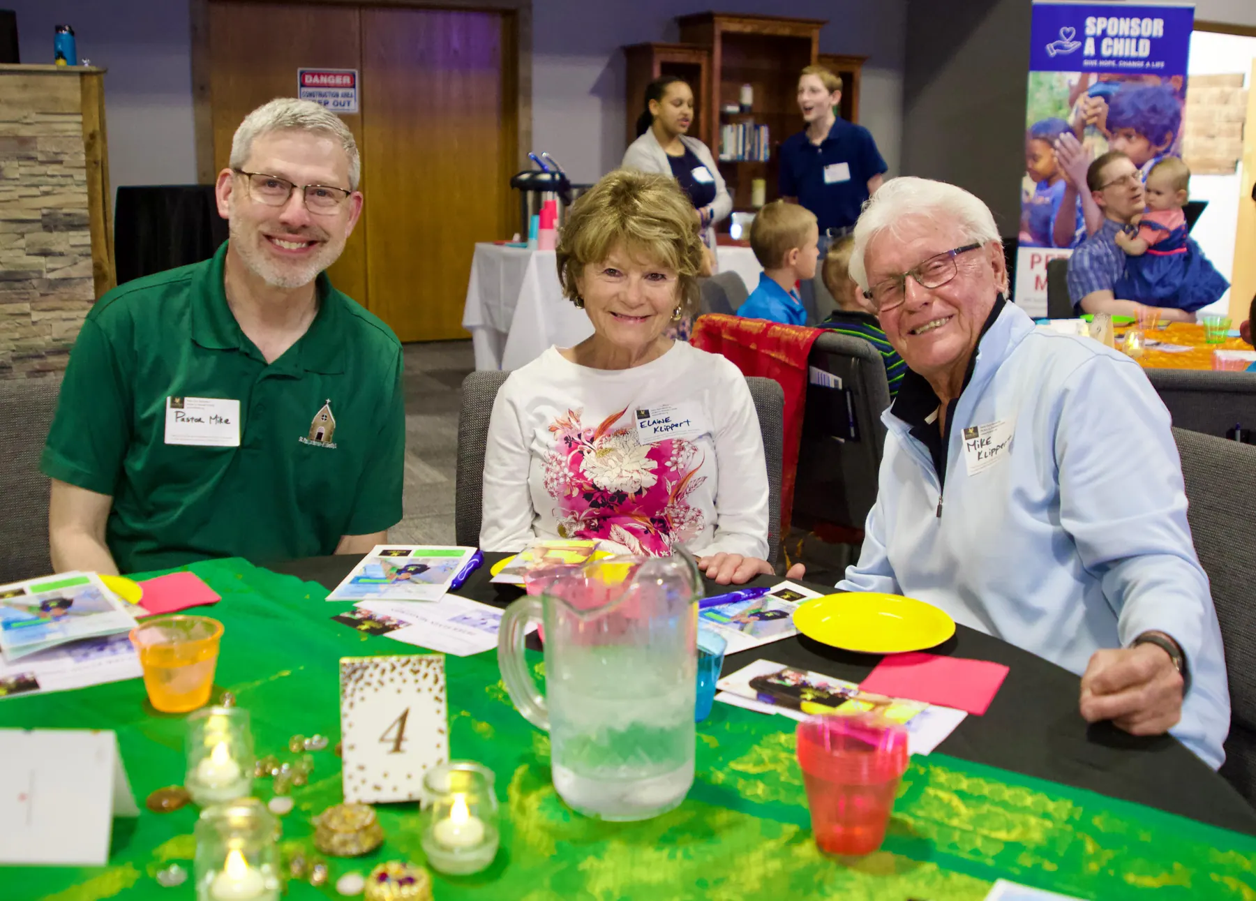 Three guests seated together at table four, smiling for the camera