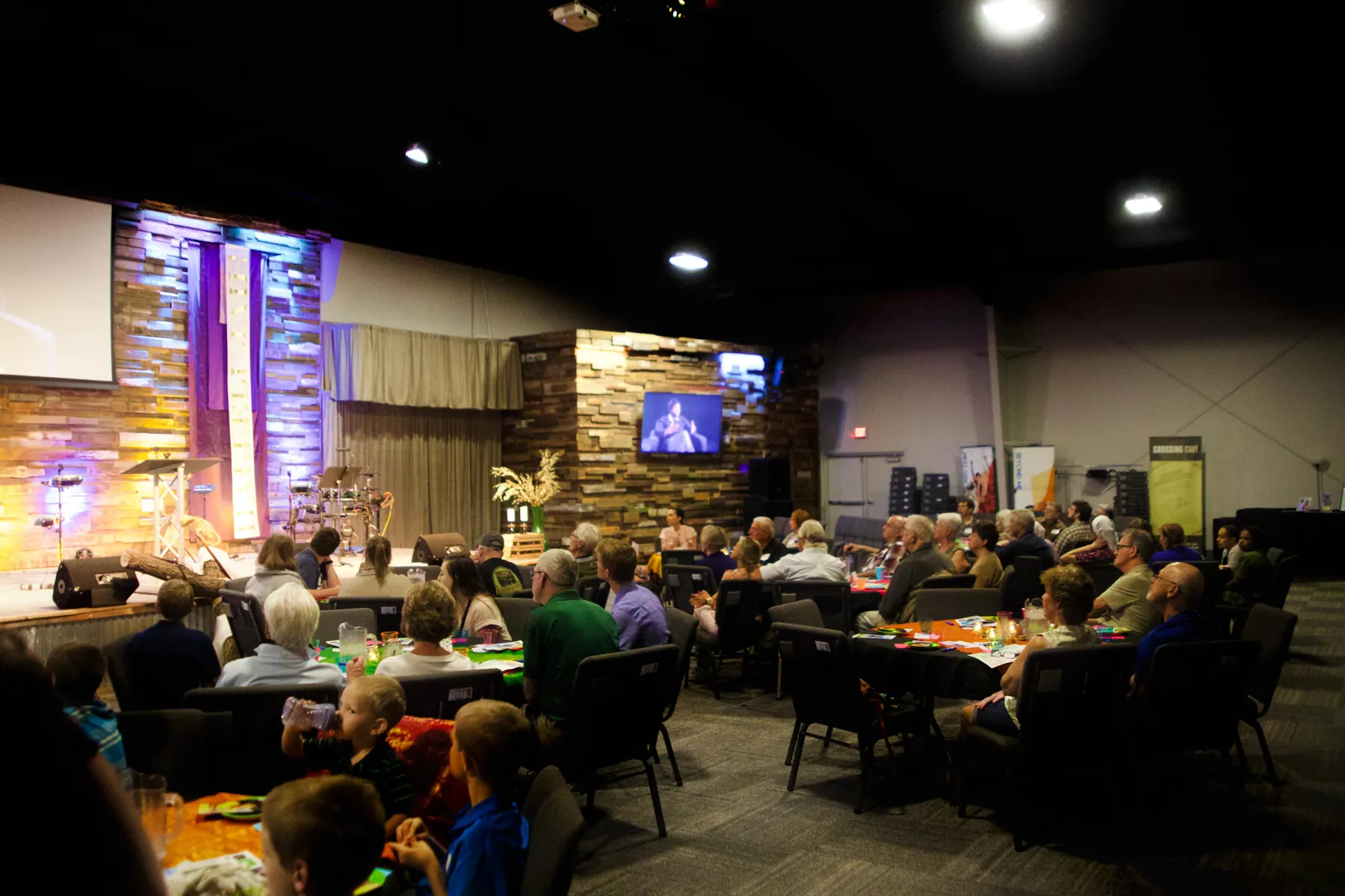 Wide view of the dimly lit benefit hall during a presentation