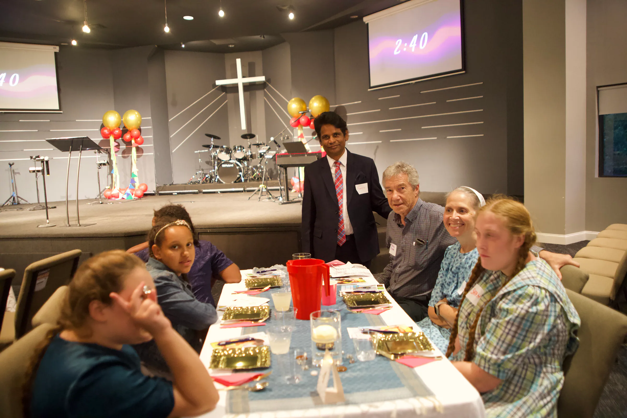 A ministry leader standing with guests at their table