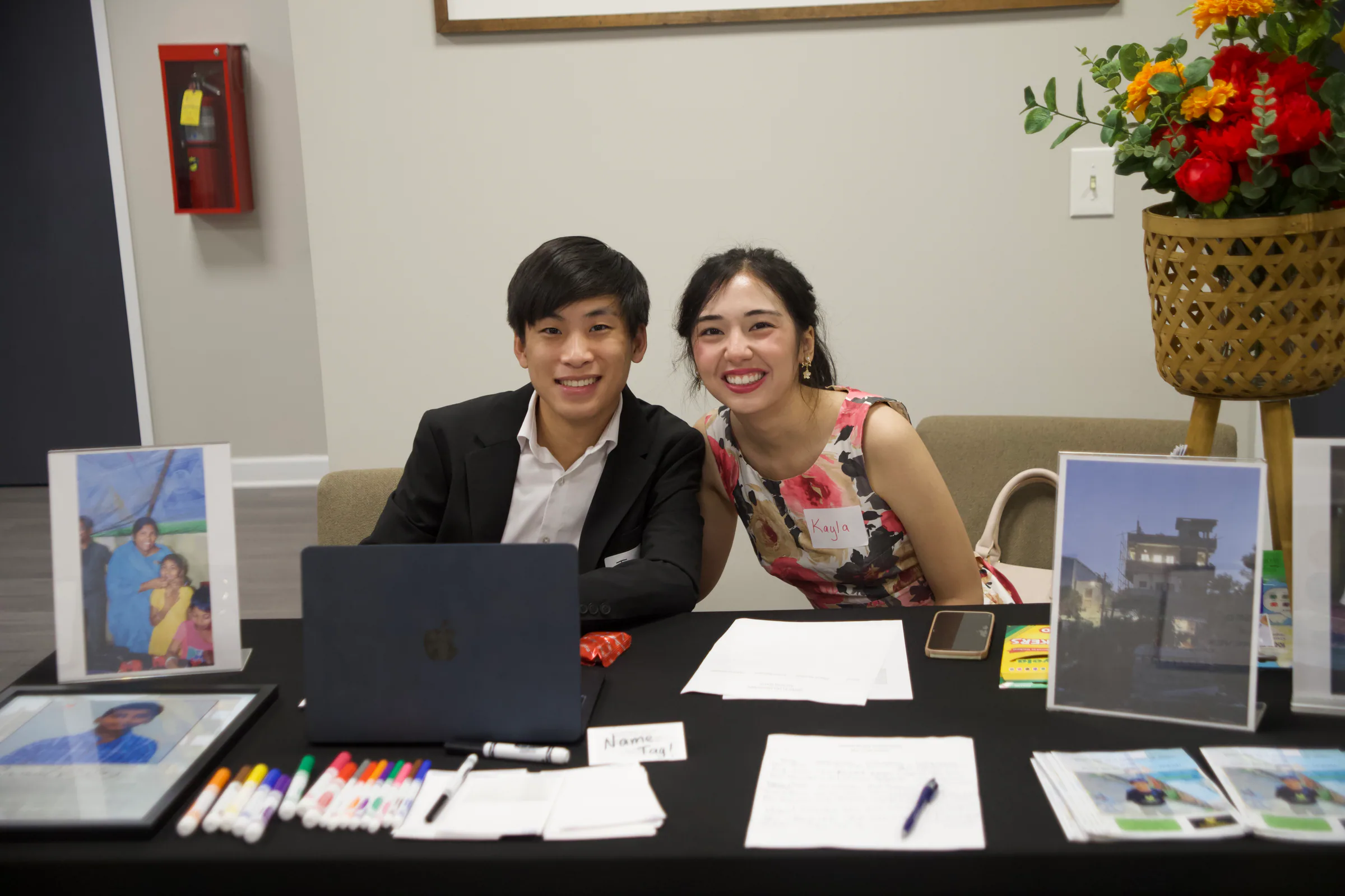 Two volunteers smiling at the welcome table