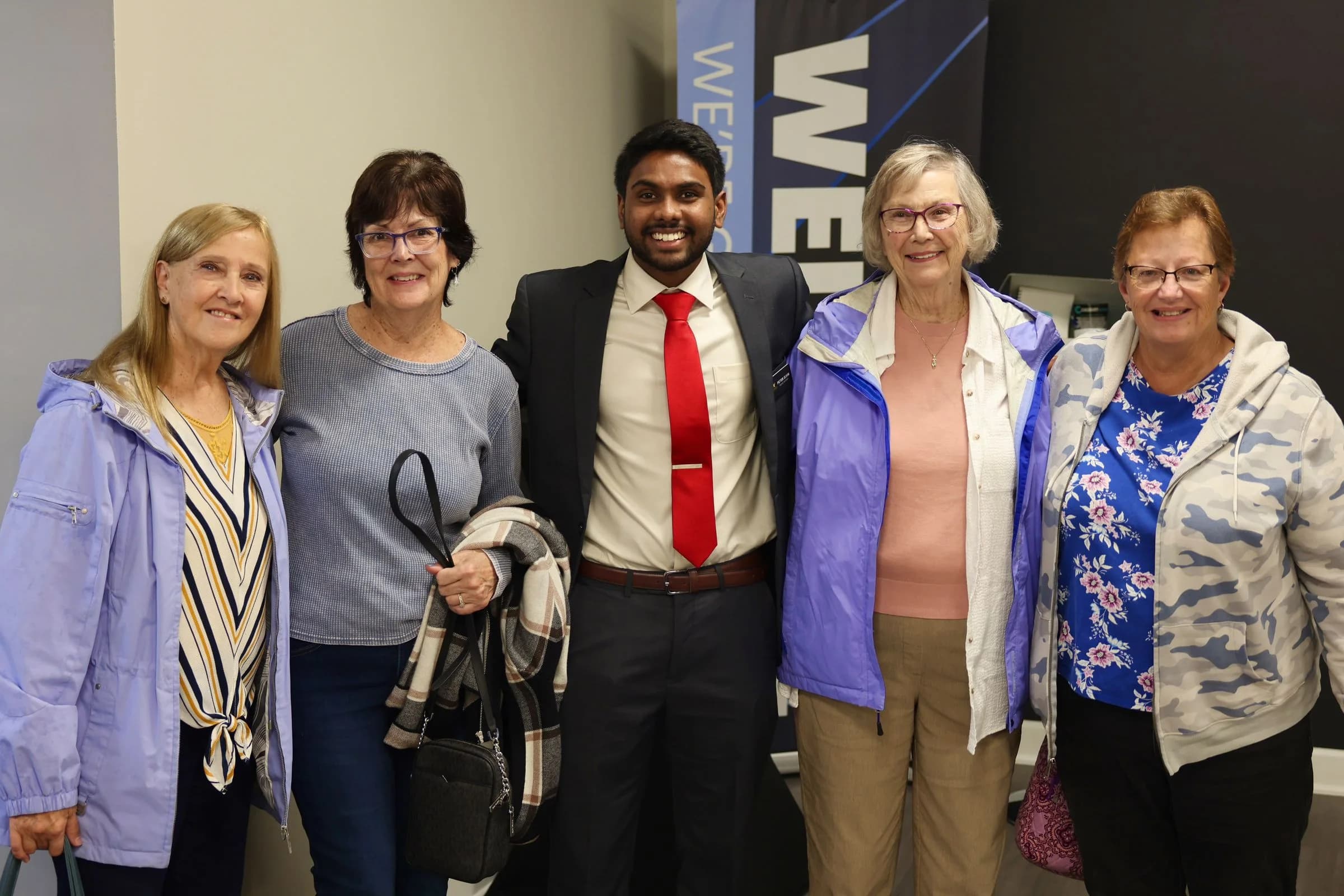 A ministry leader standing with four guests