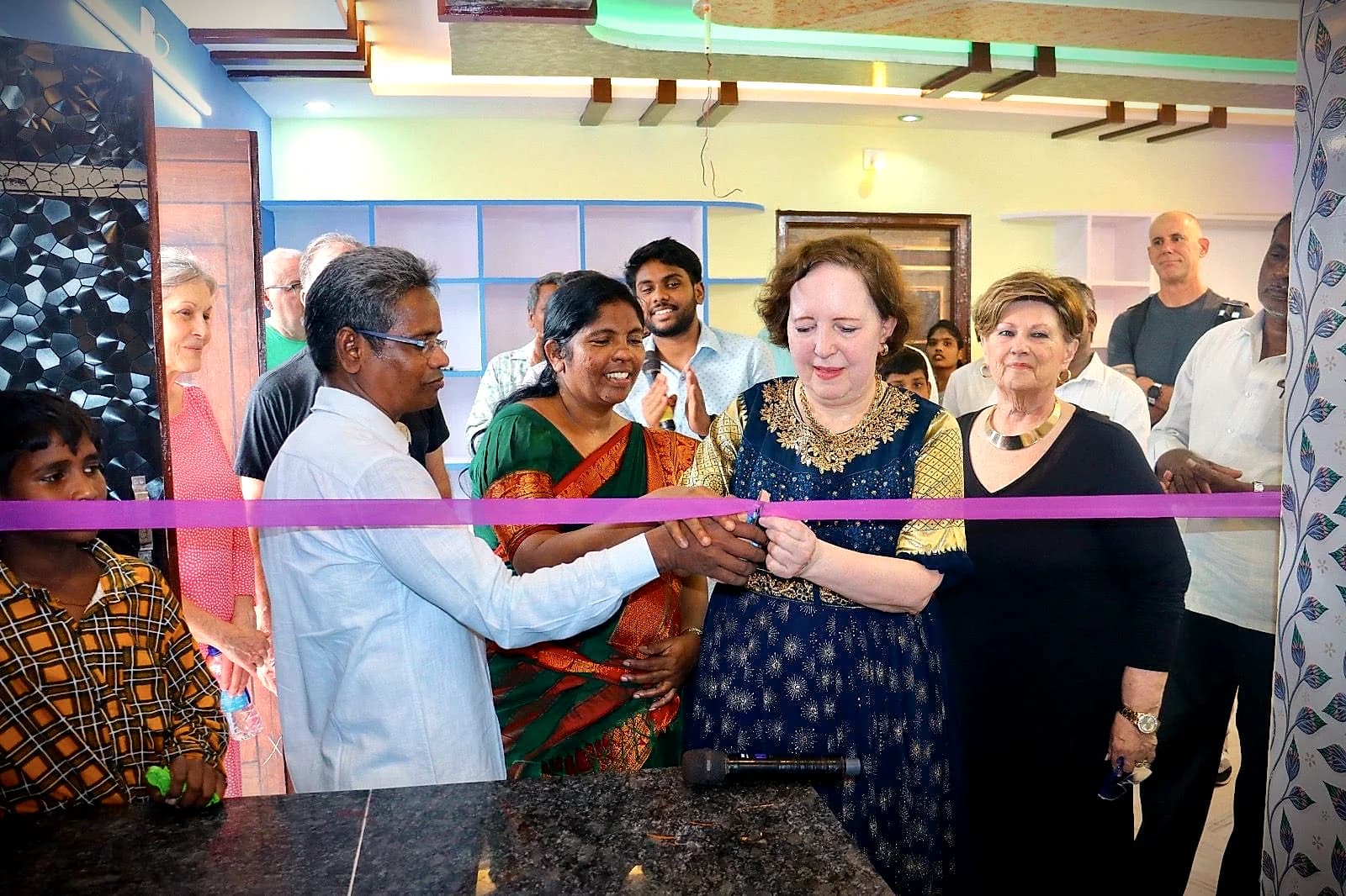 Leaders and guests cutting a ribbon at a building dedication