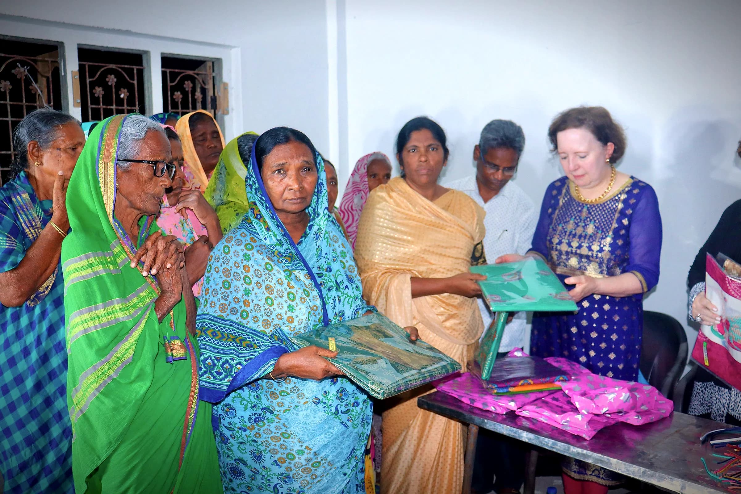 Women in bright saris receiving gifts