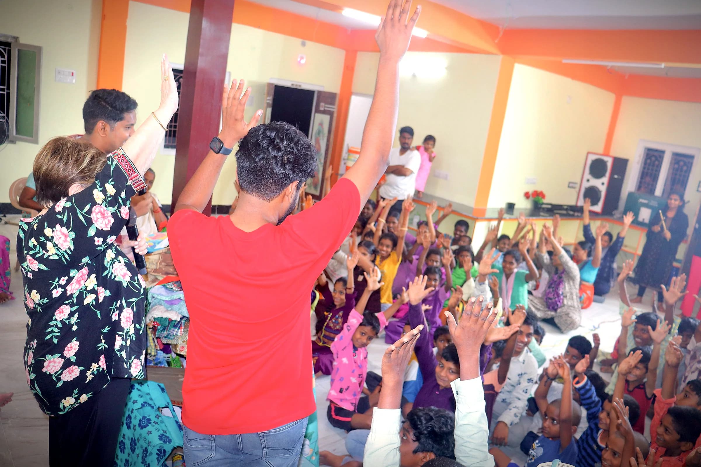 Children raising their hands during a children's program