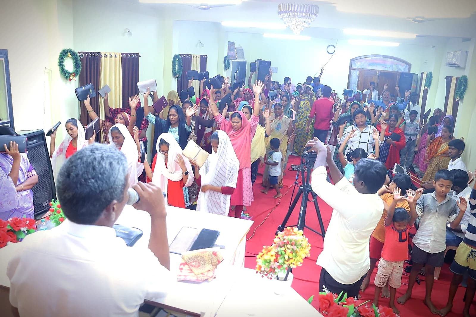 A celebration service with a room full of people praising