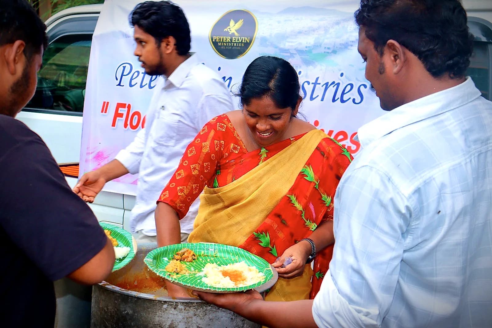 Volunteers serving plates of hot food during flood relief