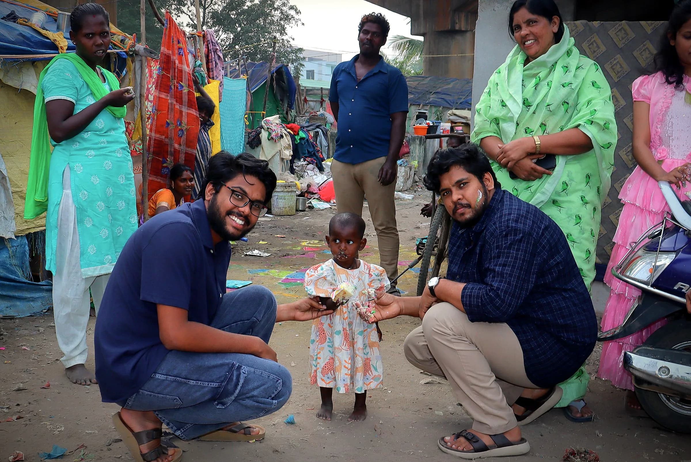 Two team members kneeling to greet a toddler
